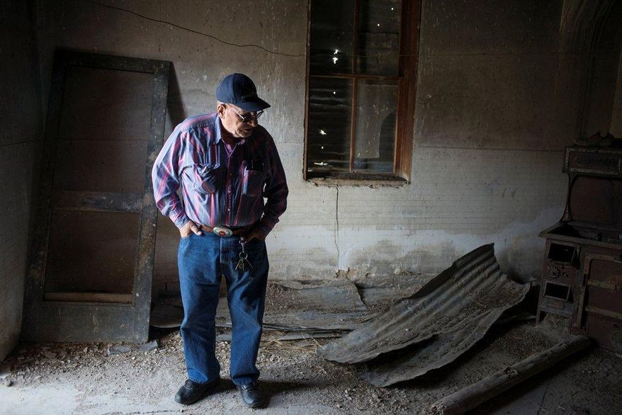 Clif Ritchie looks at the disrepair in one of the rooms in the icehouse building at the historic LX Bar Ranch in Campbell County, Wyo., on Wednesday, April 1, 2015. Ritchie lived on the ranch as a child in the early 1950s. The state of Wyoming is taking over care of the ranch and will spend $280,000 to make repairs to buildings. (AP Photo/Gillette News Record, Tim Goessman) TV OUT