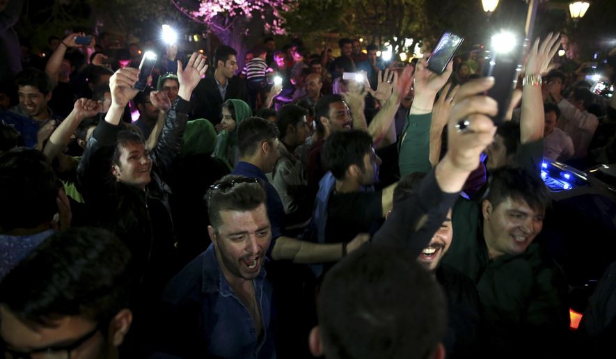 Iranians celebrate a framework agreement on Iran's nuclear program between their country and six world powers, in a street in Tehran, Iran, Friday, April 3, 2015. For the second consecutive night in Tehran, hundreds of Iranians celebrated the deal in major streets and squares. Carrying flags of Iran, singing and dancing, many chanted in support to President Hassan Rouhani and Foreign Minister Mohammad Javad Zarif. (AP Photo/Vahid Salemi)