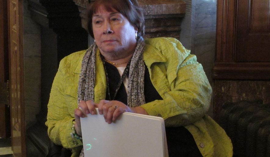 In this photo from Wednesday, April 1, 2015, Phyllis Gilmore, secretary of the Kansas Department for Children and Families, follows a debate in the state Senate over tighter rules for social services programs, at the Statehouse in Topeka, Kan. Legislators have approved a bill that Gilmore says furthers her department's goal of moving people from state assistance to jobs. (AP Photo/John Hanna)
