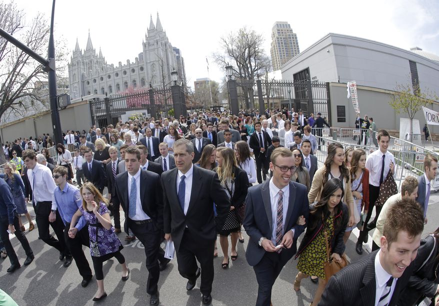People walk past the Salt Lake Temple on the way to the Conference Center during the two-day Mormon church conference Saturday, April 4, 2015, in Salt Lake City. Mormon leaders once again used their biannual conference Saturday to outline the faith's commitment the belief that marriage is an institution exclusive to a man and a woman. (AP Photo/Rick Bowmer)