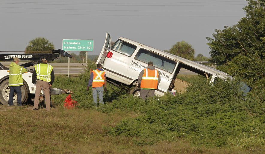 FILE - In this March 30, 2015 file photo, workers pull a van out of a canal at the intersection of US 27 and State Road 78 West, near Moore Haven, Fla. Federal transportation officials are investigating the crash that killed eight members of a Florida church who were riding in a type of van that has raised safety alarms for many years. It’s unknown what caused the overloaded 15-passenger van to plunge into the ravine, but the tragedy is giving fresh exposure to repeated warnings about the vehicles popular with budget-minded houses of worship, schools and other nonprofits. (AP Photo/Luis M. Alvarez)