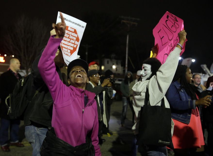 FILE - In this March 12, 2015 file photo, people demonstrate across the street from the Ferguson Police Department. Whites in the United States approve of police officers hitting people in far greater numbers than blacks and Hispanics do, at a time when the country is struggling to deal with police use of deadly force against men of color, according to a major American trend survey. (AP Photo/Jeff Roberson, File)