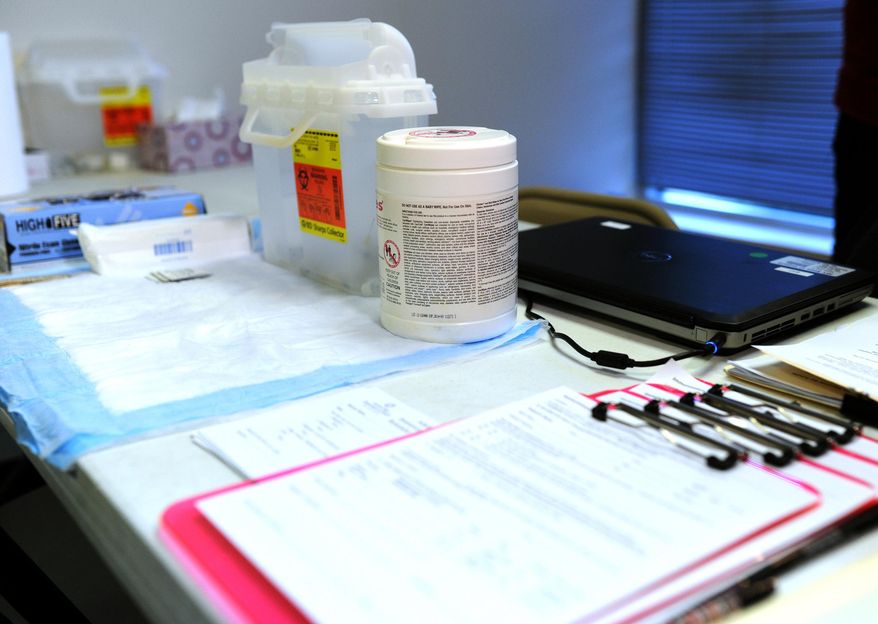 Substance abuse treatment and HIV/AIDS prevention and treatment information, with a container of clean syringes and other medical supplies are on display at a table inside the immunization office at the "one-stop shop" in Austin, Ind., Saturday, April 4, 2015. State and local health officials began a needle-exchange program Saturday where an HIV outbreak among intravenous drug users has grown to nearly 90 cases. Scott County's needle-exchange program was created through an emergency executive order signed last week by Gov. Mike Pence in an attempt to curb the state's largest-ever HIV outbreak. (AP Photo/News and Tribune, Tyler Stewart)