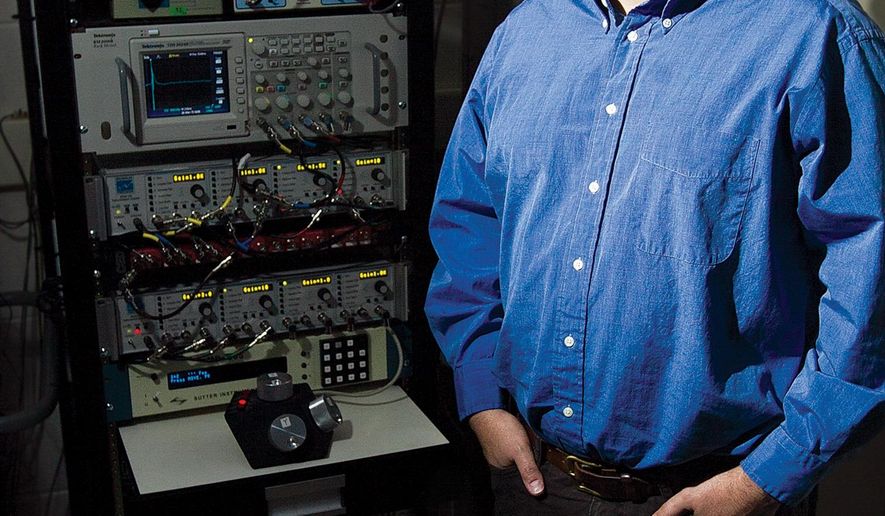 University of Wyoming assistant professor in the Department of Zoology and Physiology stands next to an amplifier feeding an oscilloscope in his biology lab on March 25, 2015 in Laramie. The oscilloscope provides a visual reading of “songs” created by birds inside the adjacent noise control systems. (AP Photo/Laramie Daily Boomerang, Jeremy Martin)