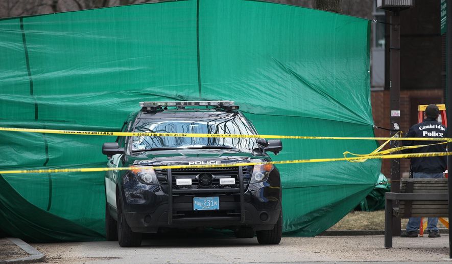 In this April 4, 2015 photo, police stand by where a body was discovered in Cambridge, Mass. Authorities are expected to reveal more details about the weekend discovery of human remains when a suspect appears in court on related charges. (AP Photo/The Boston Globe, Wendy Maeda)