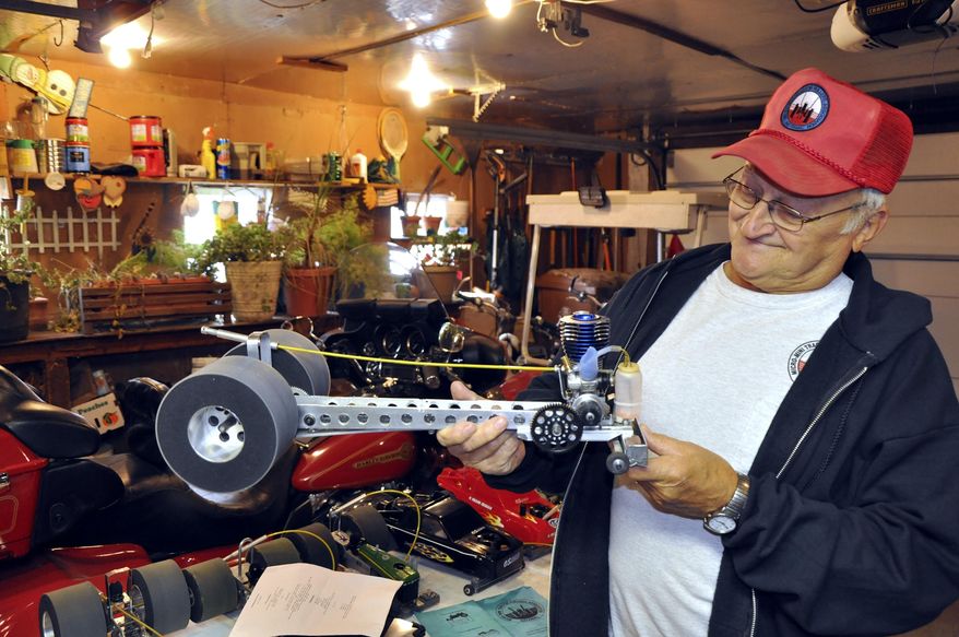 Bill Vote displays a 1/16 scale tractor that he uses in mini-micro tractor pulling competitions on March 25, 2015 in Farnhamville, Iowa. He said a machine like that one is capable of pulling close to 1,000 pounds. (AP Photo/The Messenger, Bill Shea)