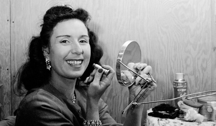FILE - In this Jan. 24, 1964 file photo, Jenny Wallenda, a member of the famous Wallenda high wire act, applies makeup in a dressing room prior to appearing at opening of the Shrine Circus in Detroit. Wallenda, the matriarch of the famous family of high-flying circus performers, died late Saturday, April 4, 2015, at her home in Sarasota, Fla., according to family members. She was 87. (AP Photo/Alvan Quinn, File)