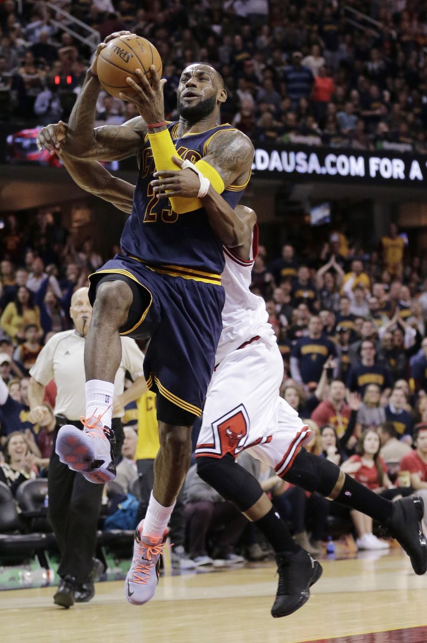 Cleveland Cavaliers' LeBron James, front, is fouled by Chicago Bulls Jimmy Butler during the third quarter of an NBA basketball game Sunday, April 5, 2015, in Cleveland. The Cavaliers defeated the Bulls 99-94. (AP Photo/Tony Dejak)