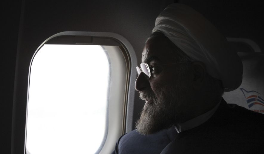 FILE - In this Monday, June 10, 2013, photo, Iranian President-elect Hassan Rouhani, a former Iran's top nuclear negotiator, looks on in his plane during his presidential election campaign tour to northwestern Iran. If, as critics contend, the nuclear framework deal between world powers and Tehran ends up projecting U.S. weakness instead, that could embolden rogue states and extremists alike, and make the region's vast array of challenges even more impervious to Western intervention. (AP Photo/Vahid Salemi, File)