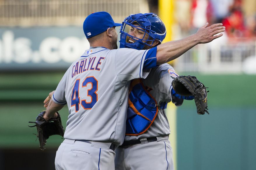 New York Mets relief pitcher Buddy Carlyle, left, celebrates with catcher Travis d'Arnaud after earning a save in a 3-1 opening day victory over the Washington Nationals at Nationals Park on Monday, April 6, 2015, in Washington. (AP Photo/Evan Vucci)