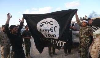 Iraqi security forces and allied Shiite militiamen celebrate March 31, 2015, as they hold a flag of the Islamic State group they captured in Tikrit, 80 miles (130 kilometers) north of Baghdad, Iraq. Iraqi forces battled Islamic State militants holed up in downtown Tikrit, going house to house Tuesday in search of snipers and booby traps, and the prime minister said security forces had reached the heart of the city. (Associated Press) **FILE**