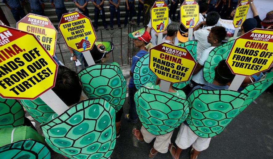 Police face off with protesters dressed as green sea turtles during a rally last year in front of the Chinese Consulate at the financial district of Makati city to protest poaching in the South China Sea. Beijing&#39;s accelerated land reclamation in recent years has only escalated the friction among claimants. In particular, China&#39;s expansion in Johnson and Gaven reefs threatens to wreck rich fishing grounds and valuable coral reefs in the archipelago. (Associated Press)