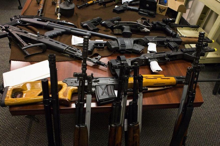 Weapons lay displayed on a table before a news conference about how the weapons, as well as ammunition, were discovered in the home of two local school bus drivers thought to be part of the Michigan Militia on Tuesday, April 7, 2015 at the Genesee County Sheriff's Department in Flint, Mich. The guns were seized after investigators claimed they were purchased with money embezzled by the couple. (AP Photo/The Flint Journal, Brittany Greeson)