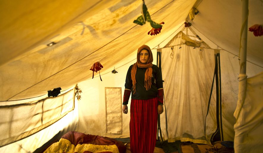 In this Monday, March 16, 2015 photo, pregnant Syrian refugee Wadhah Hamada, 22, poses for a portrait inside her tent at an informal settlement near the Syrian border, on the outskirts of Mafraq, Jordan. Hamada, who fled al-Hasaka, Syria, says she has no clue how her four-month pregnancy is progressing. “I can’t afford to pay 50 Jordanian dinars ($70) for my ultrasound and other medical checks,” she says. “Our future is dark, my life is in a tent and my first child’s life won&#x27;t be different.” (AP Photo/Muhammed Muheisen)