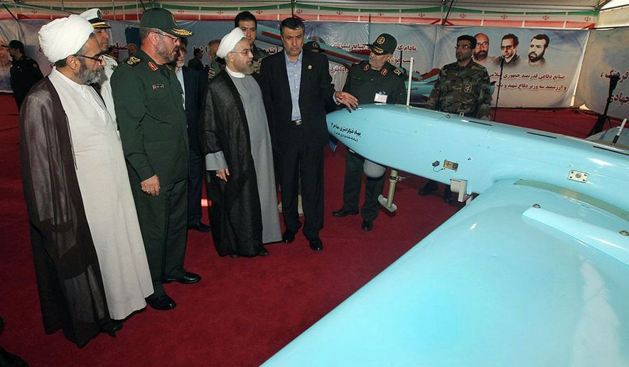 Iran&#39;s President Hassan Rouhani (third from left), accompanied by Defense Minister Hossein Dehghan (second from left) looks at a &quot;Mohajer-4&quot; Iran-made drone while visiting a defense industry display in Tehran. (Associated Press)