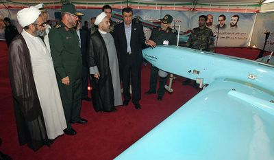 Iran&#x27;s President Hassan Rouhani (third from left), accompanied by Defense Minister Hossein Dehghan (second from left) looks at a &quot;Mohajer-4&quot; Iran-made drone while visiting a defense industry display in Tehran. (Associated Press)
