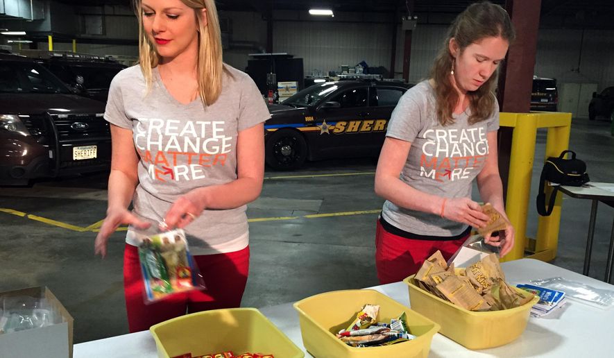 FOR RELEASE MONDAY, APRIL 13, 2015, AT 12:01 A.M. CDT.-Staff from the nonprofit group Matter worked to fill the food boxes with raisins, oatmeal and granola bars Wednesday, April 8, 2015. Matter, formerly known as Hope for the City, works on food issues locally and internationally. Besides their standard tools, Hennepin County sheriff's deputies patrolling the streets of downtown Minneapolis this summer will be packing a box filled with oatmeal and other healthy foods. (AP Photo/Minnesota Public Radio, Jon Collins)