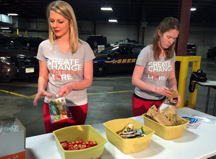 FOR RELEASE MONDAY, APRIL 13, 2015, AT 12:01 A.M. CDT.-Staff from the nonprofit group Matter worked to fill the food boxes with raisins, oatmeal and granola bars Wednesday, April 8, 2015. Matter, formerly known as Hope for the City, works on food issues locally and internationally. Besides their standard tools, Hennepin County sheriff's deputies patrolling the streets of downtown Minneapolis this summer will be packing a box filled with oatmeal and other healthy foods. (AP Photo/Minnesota Public Radio, Jon Collins)