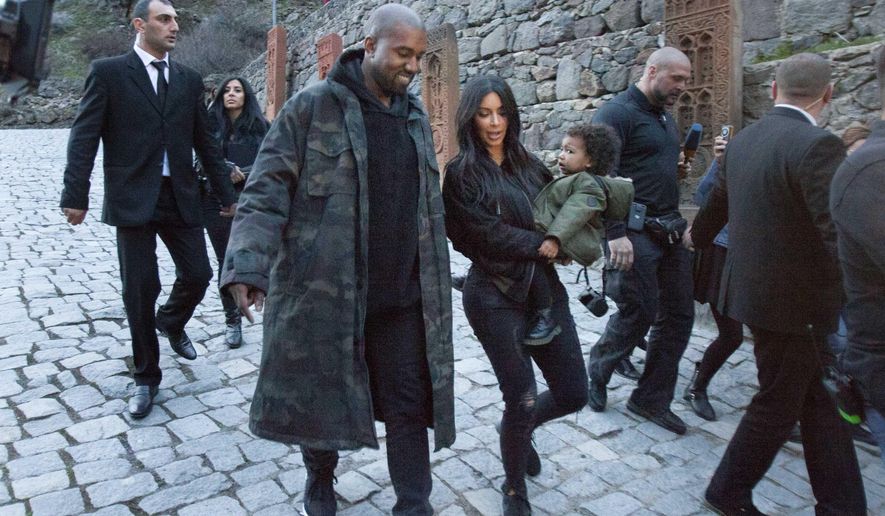 U.S. TV personality Kim Kardashian, center, carriers daughter North as she walks alongside her husband Kanye West visit the Geghard Monastery near Goght, Armenia, Thursday, April 9, 2015. Kim Kardashian, husband Kanye West, daughter North and sister Khloe are in the Kardashian ancestral homeland on a high-visibility visit ahead of this month's observing of the centennial of the mass killing of Armenians by Ottoman Turks. (AP photo/Vahan Stepanyan, PAN Photo)