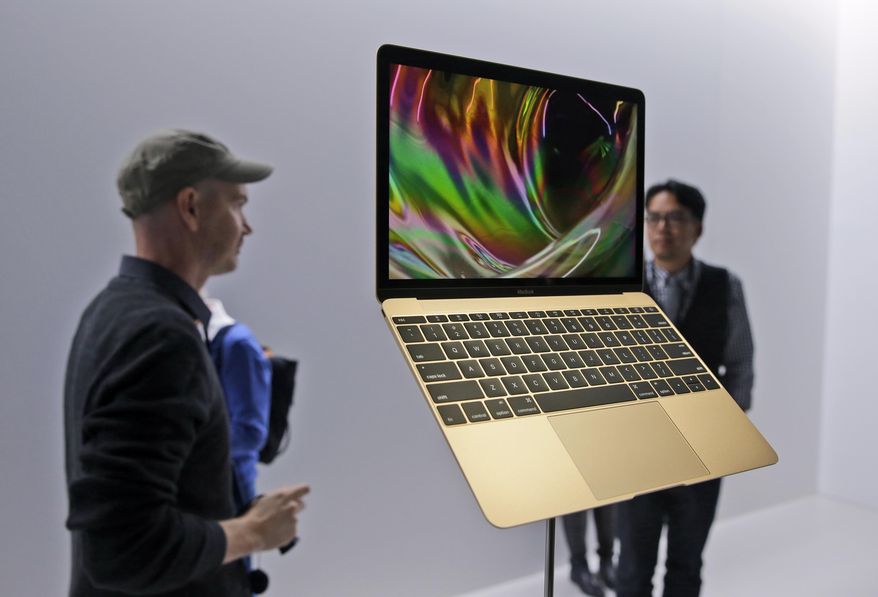 In this March 9, 2015 photo, members of the media and Apple guests get a look at the new MacBook in the demo room after an Apple event in San Francisco. The company will debut the new laptop on Friday, April 10, 2015. (AP Photo/Eric Risberg, File)