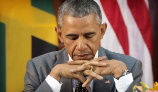President Barack Obama looks down at his notes during a bilateral meeting with Jamaican Prime Minister Portia Simpson-Miller at the Jamaica House, Thursday, April 9, 2015, in Kingston, Jamaica. (AP Photo/Pablo Martinez Monsivais)