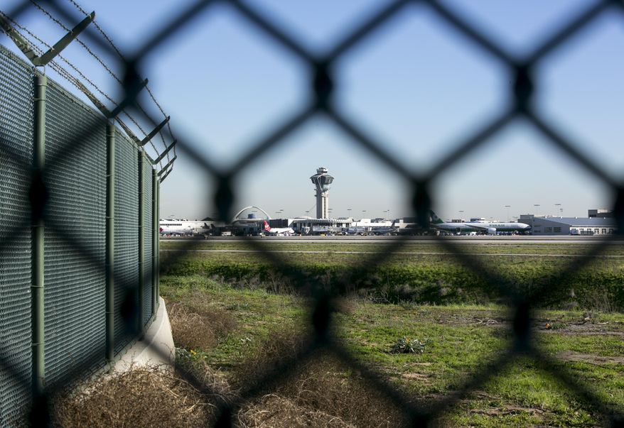 This Friday, Jan. 23, 2015 photo shows the Los Angeles International Airport control tower though the airport's perimeter fence. In the U.S., officials said there is neither the appetite nor funding to create fortress-like perimeters. And no solution is foolproof, according to airport security experts. (AP Photo/Damian Dovarganes)
