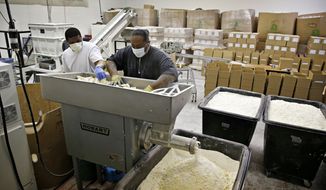 In this March 20, 2015, photo, Jabir Hennix, left, and Sia Leleua grind up used bars of soap at Clean the World in Las Vegas. The non-profit  initiative recycles soap from hotels to distribute in developing countries. (AP Photo/John Locher)