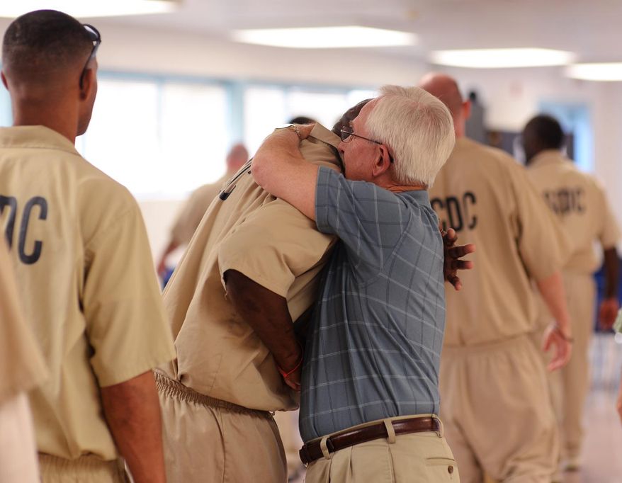 Former judge and associate state Supreme Court justice E.C. Burnett III visits with inmates at Tyger River Correctional Institution in Enoree, S.C. on March 16, 2015. Every Monday, Burnett and the men of Mt. Calvary Presbyterian Church, visit the correctional institution for a night worship service. They may be the only visitors some inmates have at the medium-security prison. (AP Photo/Spartanburg Herald-Journal,Tim Kimzey)