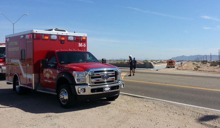 In this photo provided by Yuma Fire Department, authorities work a perimeter near a canal in Yuma, Ariz., Saturday, April 11, 2015. Twin 18-month-old boys were pronounced dead at a hospital after being pulled from the Arizona canal, police said Saturday. (AP Photo/Yuma Fire Department via Public Affairs for Yuma County, Kevin Tunell)