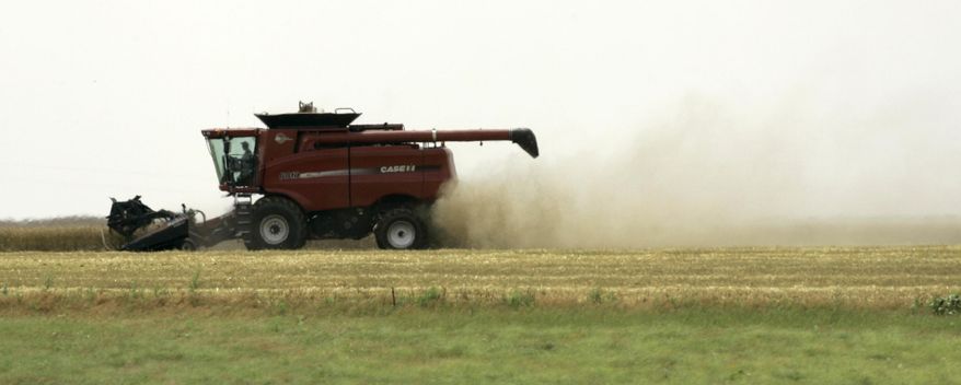 FILE - In this June 19, 2007 file photo, wheat straw and dust blow from the back of a combine harvesting the grain in a field near Mullinville, Kansas. The maker of Kleenex and Scott brand products is unveiling a line of tissues and towels this month aimed at its commercial customers that will incorporate wheat straw and bamboo, a move the company hopes will provide a rapidly renewable source of fiber that will also give farmers a new market for the plant residue left behind after the grain is harvested. (AP Photo/Charlie Riedel, File)