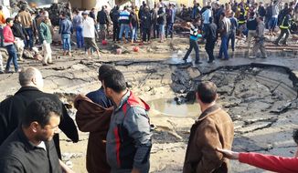 Egyptians gather around the crater following a bombing that struck a main police station in the capital of the northern Sinai province in el-Arish, Egypt, Sunday, April 11, 2015. The explosion comes hours after a roadside bomb killed six soldiers traveling south of el-Arish in an armored vehicle. The region has been hit by an Islamic insurgency by a group that recently pledged allegiance to the Islamic State. (AP Photo/Muhamed Sabry)