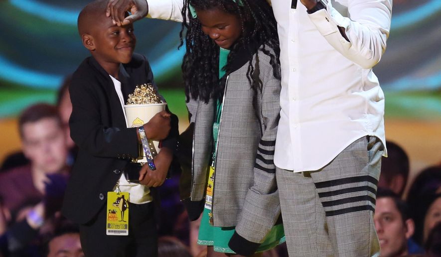 Kevin Hart, right, appears on stage with his kids Hendrix Hart, left, and Heaven Hart as he accepts the comedic genius award at the MTV Movie Awards at the Nokia Theatre on Sunday, April 12, 2015, in Los Angeles. (Photo by Matt Sayles/Invision/AP)