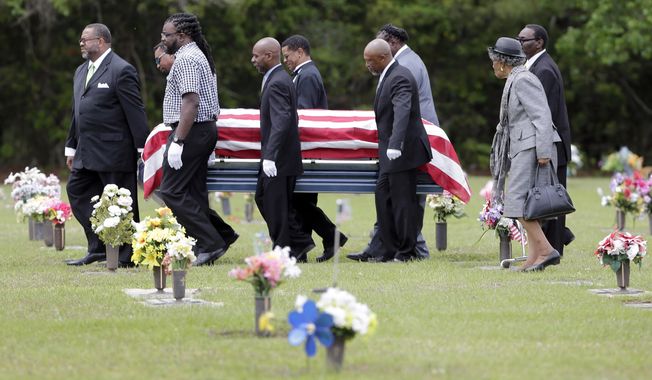 Pallbearers walk Walter Scott&#x27;s casket to the gravesite for his burial service in Charleston, S.C. on Saturday, April 11, 2015. Scott was fatally shot by a North Charleston, S.C., police officer a week earlier after a traffic stop. Officer Michael Slager has been charged with murder.