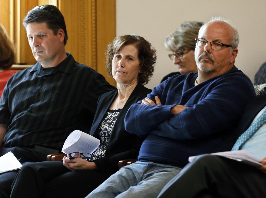 Jane Dougherty, center, whose sister was killed in the Newtown, Conn., school shooting in 2012, sits with Dave Hoover, left, and Tom Sullivan, both of whom lost close family members in the Aurora, Colo., movie theater shooting, listening to testimony on bills aimed at undoing recent firearm laws, at the state Legislature, in Denver, Monday April 13, 2015. Lawmakers considered several proposals, including two Republican-sponsored bills to eliminate gun-control measures passed by Democrats in 2013. (AP Photo/Brennan Linsley)
