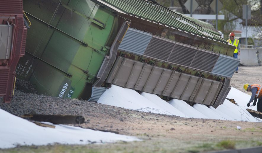 A Union Pacific worker pulls severed wires from spilled dry ammonia at the scene where a train carrying the substance derailed late Sunday night near the Martin Drake power plant in Colorado Springs, Colo., Monday, April 13, 2015. No one was injured and there were no evacuations. (Mark Reis/The Gazette via AP) MAGS OUT