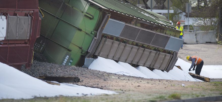 A Union Pacific worker pulls severed wires from spilled dry ammonia at the scene where a train carrying the substance derailed late Sunday night near the Martin Drake power plant in Colorado Springs, Colo., Monday, April 13, 2015. No one was injured and there were no evacuations. (Mark Reis/The Gazette via AP) MAGS OUT