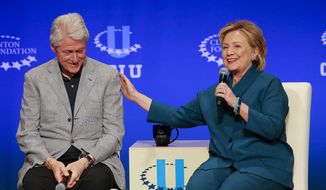Former President Bill Clinton, left, listens as former Secretary of State Hillary Rodham Clinton speaks during a student conference for the Clinton Global Initiative University at Arizona State University. (AP Photo/Matt York, File)