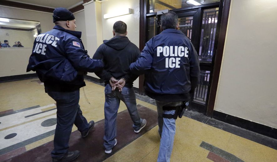 Immigration and Customs Enforcement officers escort an arrestee from an apartment building in the Bronx borough of New York during a series of early-morning raids on March 3. (Associated Press)