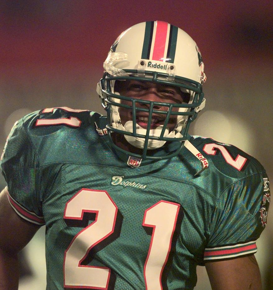 Lawerence Phillips smiles as the crowd in the stands at Pro Player Stadium calls out to him as he takes the field for the first time in a Miami Dolphins uniform Sunday Dec. 7, 1997 in Miami before a game against the Detroit Lions. Phillips signed with the Dolphins last week after a stormy stint with the Saint Louis Rams.(AP Photo/Joe Cavaretta)