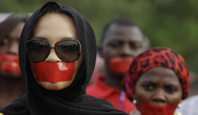 People march during a silent protest calling on the government to rescue the kidnapped girls of the government secondary school in Chibok, who were abducted a year ago, in Abuja, Nigeria, Monday, April 13, 2015. Nearly 300 schoolgirls from Chibok were abducted in a mass kidnapping on the night of April 14-15. Dozens escaped on their own but 219 remain missing. (AP Photo/Sunday Alamba)