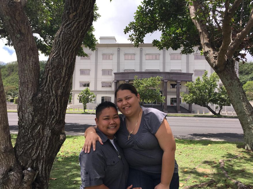 In this April 11, 2015, photo, Loretta M. Pangelinan, left, and Kathleen M. Aguero, pose for a photo in front of the U.S. District Court in Hagatna, Guam. The couple, who have been together for more than nine years, said they plan to file a lawsuit against the Government of Guam for violating their Constitutional rights of equal protection and due process at the U.S. District Court in Hagatna, Guam, Monday, April 13. (AP Photo/Grace Garces Bordallo)