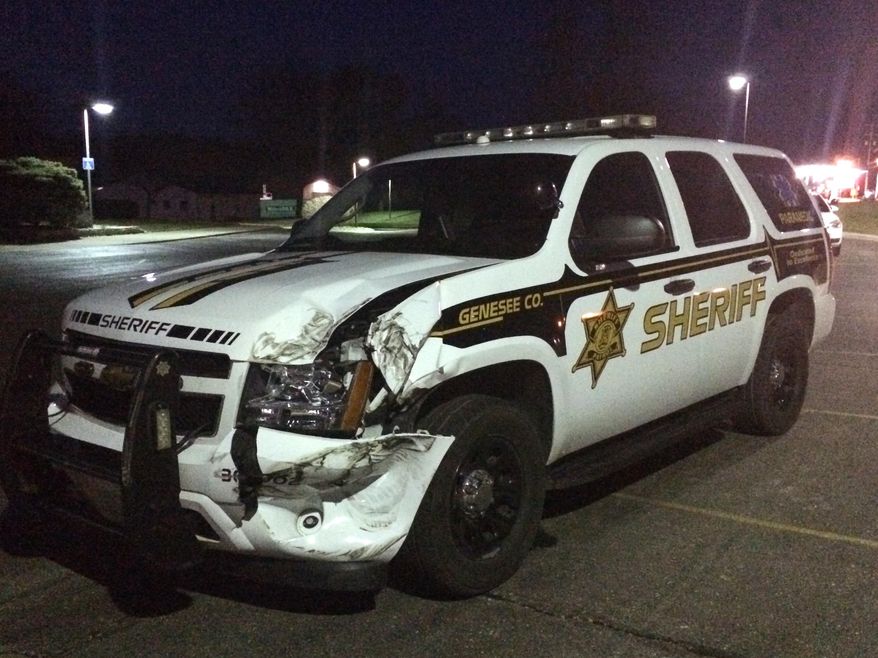 Three police vehicles were damaged Sunday, April 12, 2015, in Vienna Township after they were rammed by a person driving a pickup truck. A Genesee County Sheriff deputy and Thetford Township police officer were taken to the hospital for injuries. (Roberto Acosta/The Flint Journal-MLive.com via AP) LOCAL TELEVISION OUT; LOCAL INTERNET OUT