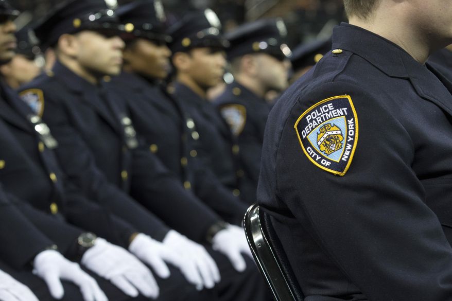 In this Dec. 29, 2014, file photo, new recruits attend their New York Police Academy graduation ceremony at Madison Square Garden in New York. (AP Photo/John Minchillo, File)