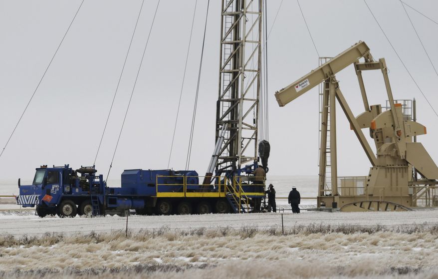 FILE - In this Dec. 15, 2014 file photo, workers drill for oil at a site near Williston, N.D. North Dakota lawmakers are looking at a project to treat and recycle oil drilling waste for road building and other uses. The measure would set aside about $65,000 for the state Health Department to monitor a project and develop standards. (AP Photo/Eric Gay, File)