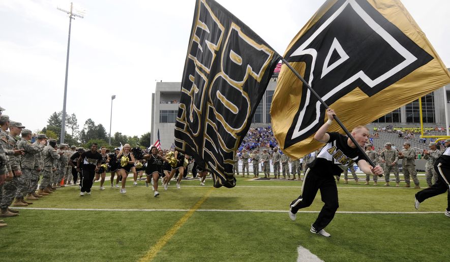 FILE - In this Sept. 6, 2014, file photo, Army cheerleaders and players take the field before an NCAA college football game against Buffalo in West Point, N.Y. Army is getting a new look. The academy unveiled a rebranding Monday night, April 13, 2015, after an 18-month collaboration with Nike.  One goal is to strengthen the connection between Army and West Point. The academy will now refer to its teams as Army West Point instead of just Army. (AP Photo/Hans Pennink, File)
