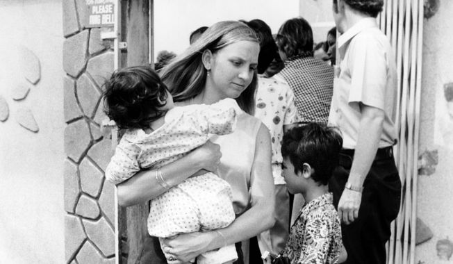 An American volunteer carries a South Vietnamese infant from a Saigon orphanage to the airport en route to the United States for adoption. More than 3,000 young Vietnamese children who were rescued during Operation Babylift in April 1975. (Associated Press)