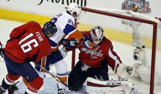 Washington Capitals right wing Eric Fehr (16) defends with goalie Braden Holtby (70) as New York Islanders center Brock Nelson (29) works in front of the net during the third period in the opening game of a first-round NHL hockey playoff series, Wednesday, April 15, 2015, in Washington. The Islanders won 4-1. (AP Photo/Alex Brandon)
