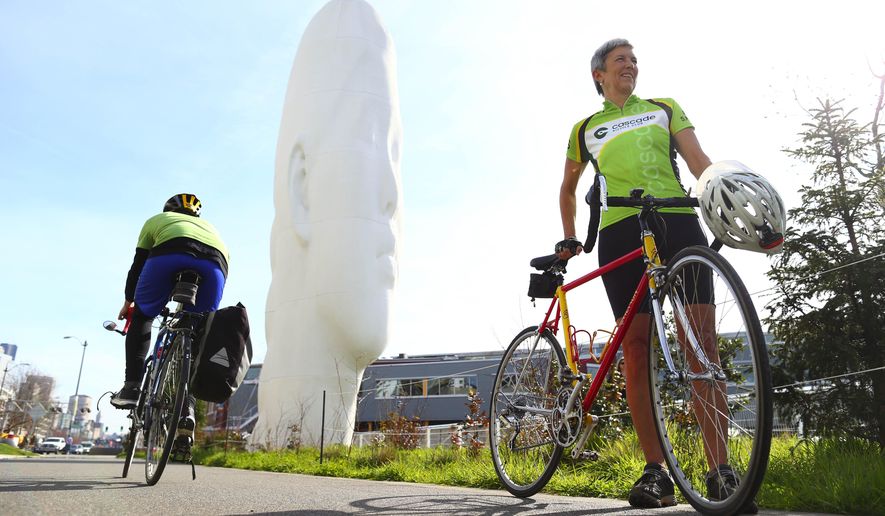 In this March 6, 2015 photo, Catherine Hennings, right, board president of Cascade Bicycle Club, pauses on the bicycle trail at Seattle’s Myrtle Edwards Park, part of an urban loop she recommends. (John Lok/The Seattle Times via AP) SEATTLE OUT; USA TODAY OUT; MAGS OUT; TELEVISION OUT; NO SALES; MANDATORY CREDIT TO BOTH THE SEATTLE TIMES AND THE PHOTOGRAPHER
