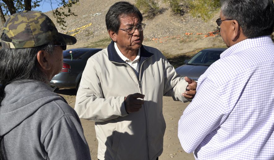 FILE - In this Nov. 2014, file photo, Navajo Nation presidential candidate Russell Begaye, center, speaks with a group during the Navajo Nation elections outside of the Shiprock Chapter House in Shiprock, N.M. Voters on the country’s largest American Indian reservation are choosing a new president who will have to deal with rampant unemployment and a lack of infrastructure while helping tribal members through a bitter dispute that has divided communities. (Alexa Rogals/The Daily Times via AP, File)