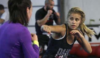 In this Monday, April 13, 2015, photo, mixed martial arts fighter Paige VanZant, right, spars with Sarah Jamila at Ultimate Fitness in Sacramento, Calif. VanZant, 21, is scheduled to fight Felice Herrig in an Ultimate Fighting Championship strawweight match in New Jersey on Saturday. (AP Photo/Rich Pedroncelli)